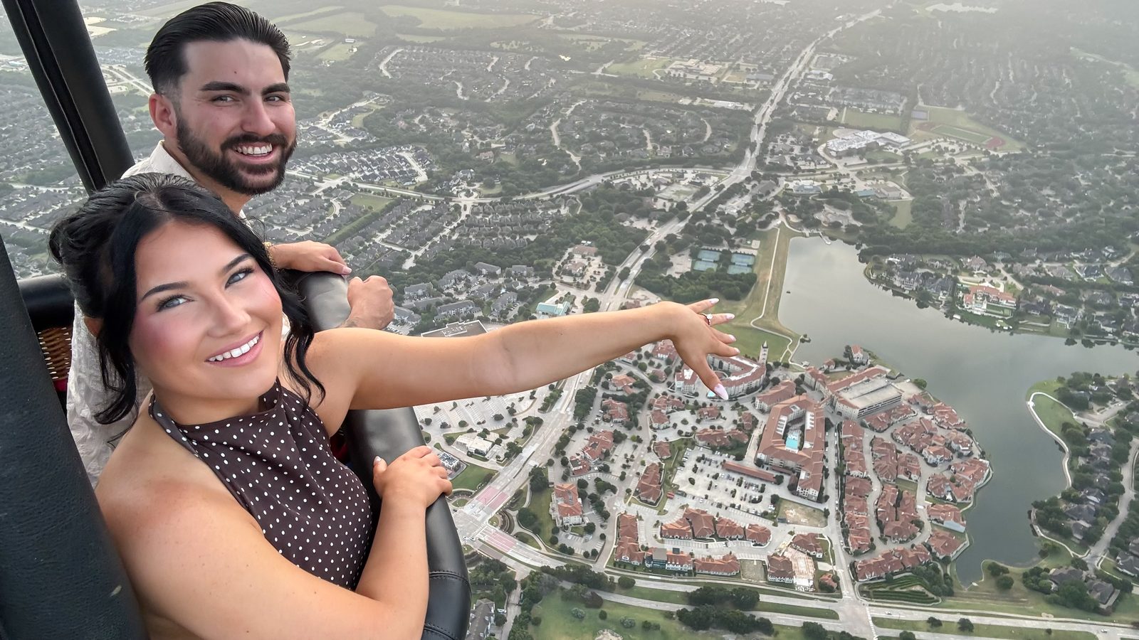 Newly engaged couple showing the ring high above North Texas during a Rohr Balloons engagement flight