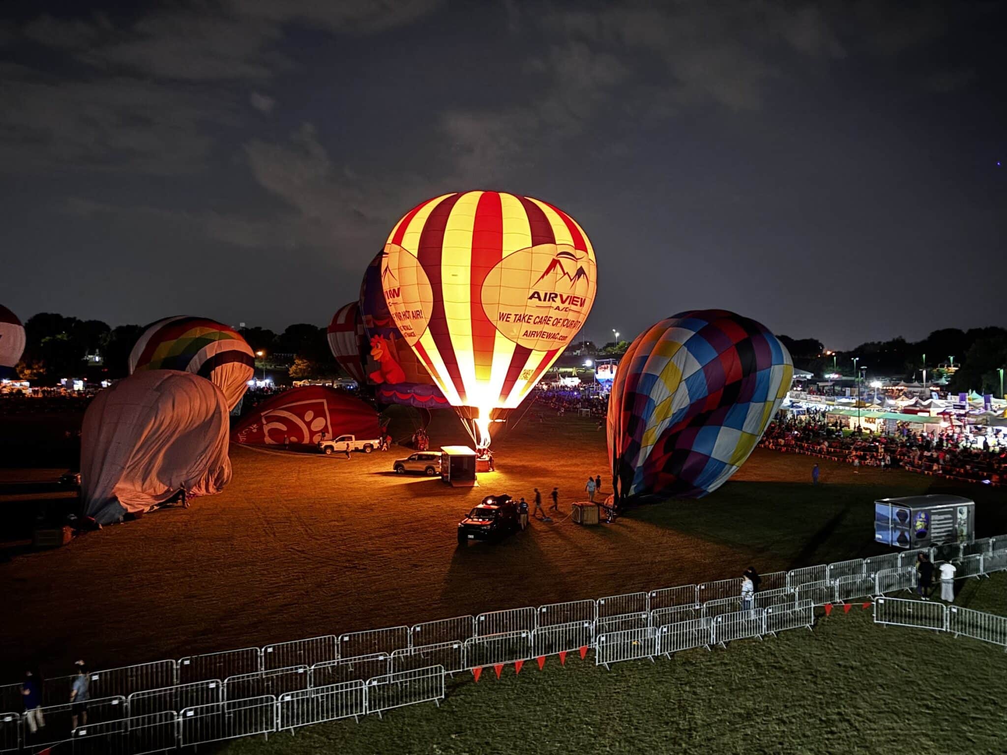 Airview A/C custom corporate hot air balloon glowing at a night festival